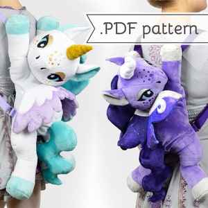 May include: Two plush unicorn backpacks, one white with teal wings and gold horn, the other purple with blue wings and a silver horn. Both have a purple strap and are worn by children in the image. .PDF pattern.