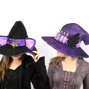 May include: Two witch hats, one black with purple trim and cat ears, the other purple with a black wing and a row of small glass vials.