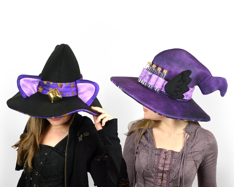 May include: Two witch hats, one black with purple trim and cat ears, the other purple with a black wing and a row of small glass vials.