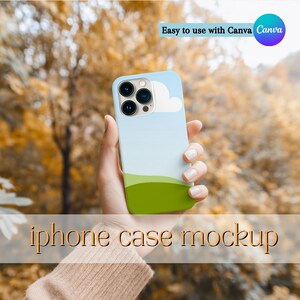 Può includere: Custodia per iPhone azzurra e verde con un design a nuvola. La custodia è tenuta in mano su uno sfondo sfocato di fogliame autunnale. Il testo "iphone case mockup" è visualizzato nella parte inferiore dell'immagine.
