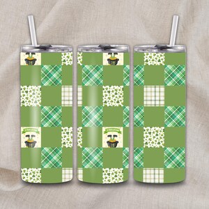 May include: Three green insulated tumblers with silver lids and straws. Each tumbler features a patchwork design with plaid, shamrock, and solid green squares. A banner with text and a pot of gold graphic is on each tumbler.