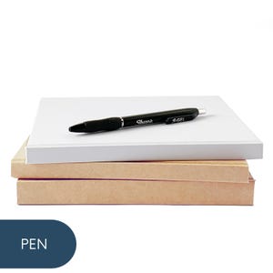 May include: A stack of three notebooks with a black pen on top. The top notebook is white, the middle notebook is pink, and the bottom notebook is brown. The pen is a black Sharpie S-Gel pen.