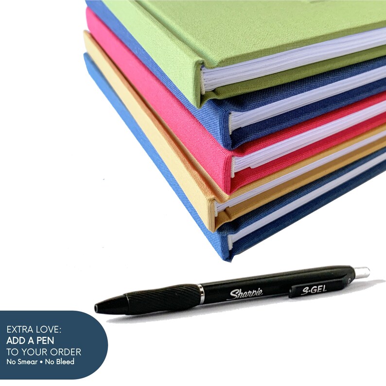 May include: A stack of colorful journals with hard covers in green, pink, yellow, and red. A black Sharpie S-Gel pen rests in front of the journals. Text on the image reads: EXTRA LOVE: ADD A PEN TO YOUR ORDER. No Smear. No Bleed.
