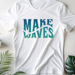 May include: White t-shirt with a blue and green gradient graphic that says "MAKE WAVES".