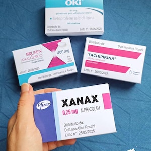Puede incluir: Cuatro cajas rectangulares de medicamentos etiquetadas como Oki, Brufen Analgesico, Tachipirina y Xanax. Cada caja muestra detalles farmacéuticos, incluyendo dosis como 80 mg, 400 mg, 500 mg y 0,25 mg, junto con información de distribución y lotes.