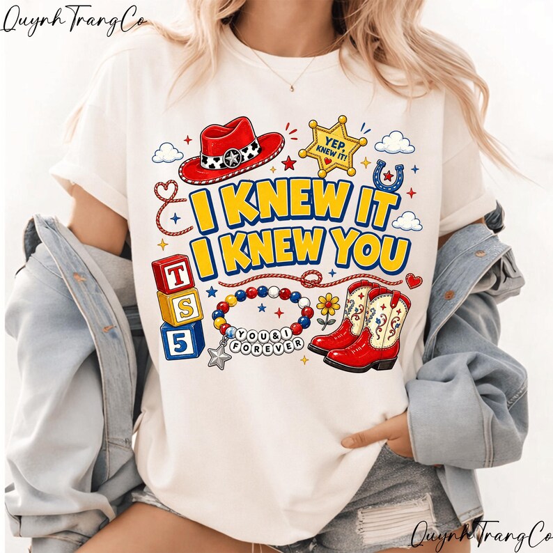 May include: A cream-colored t-shirt featuring a graphic print with a red cowboy hat, a yellow sheriff badge with the text YEP, KNEW IT!, blue and red blocks with T, S, 5, a beaded bracelet with the text YOU & I FOREVER, and red cowboy boots.