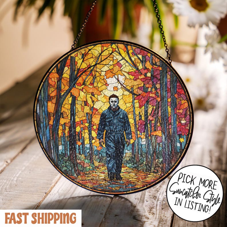 May include: Round stained glass suncatcher featuring a figure in a mask walking through a colorful autumn forest. The artwork has a black metal frame and is suspended by a chain. Text on the image says "Pick More Suncatcher Style in Listing!"