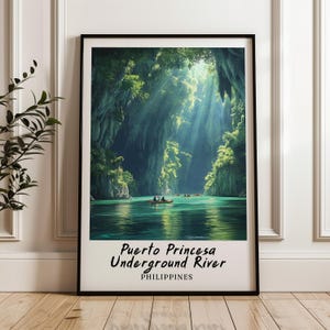 Könnte beinhalten: Gerahmter Druck des Puerto Princesa Underground River auf den Philippinen. Das Bild zeigt einen türkisfarbenen Fluss, der durch eine Höhle mit üppiger grüner Vegetation und Sonnenlicht fließt. Der Text "Puerto Princesa Underground River" befindet sich unten.