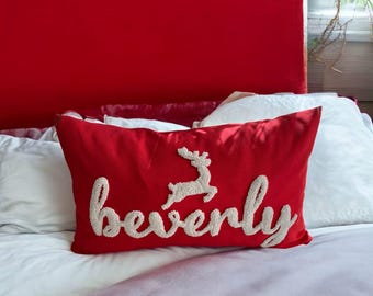 May include: Red velvet pillow with white embroidered lettering that says "Beverly" and a white embroidered reindeer design.