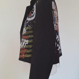 K&ouml;nnte beinhalten: Schwarzer Blazer mit einzigartigem Design. Die Jacke hat eine Collage aus Bildern und Text auf den &Auml;rmeln und dem R&uuml;cken. Der Text enth&auml;lt die W&ouml;rter "Everything" und "What". Der Blazer hat einen klassischen Kragen und vier Kn&ouml;pfe am &Auml;rmel.