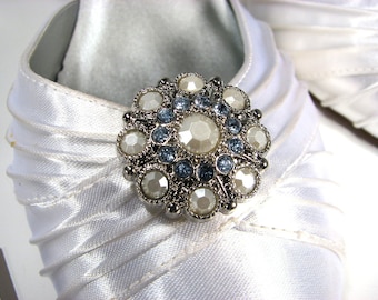 May include: White satin shoe with a silver and blue rhinestone embellishment.