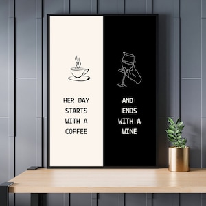Op de afbeelding: Zwart omkaderde kunstprint met een gesplitst ontwerp. Eén kant toont een illustratie van een koffiekopje met de tekst "HER DAY STARTS WITH A COFFEE". De andere kant toont een wijnglas en de tekst "AND ENDS WITH A WINE."