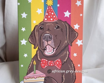 May include: A brown Labrador Retriever wearing a red and white polka dot bow tie and a red and white party hat holds a slice of cake with a lit candle on a white plate. The background is a colorful striped pattern with white stars.