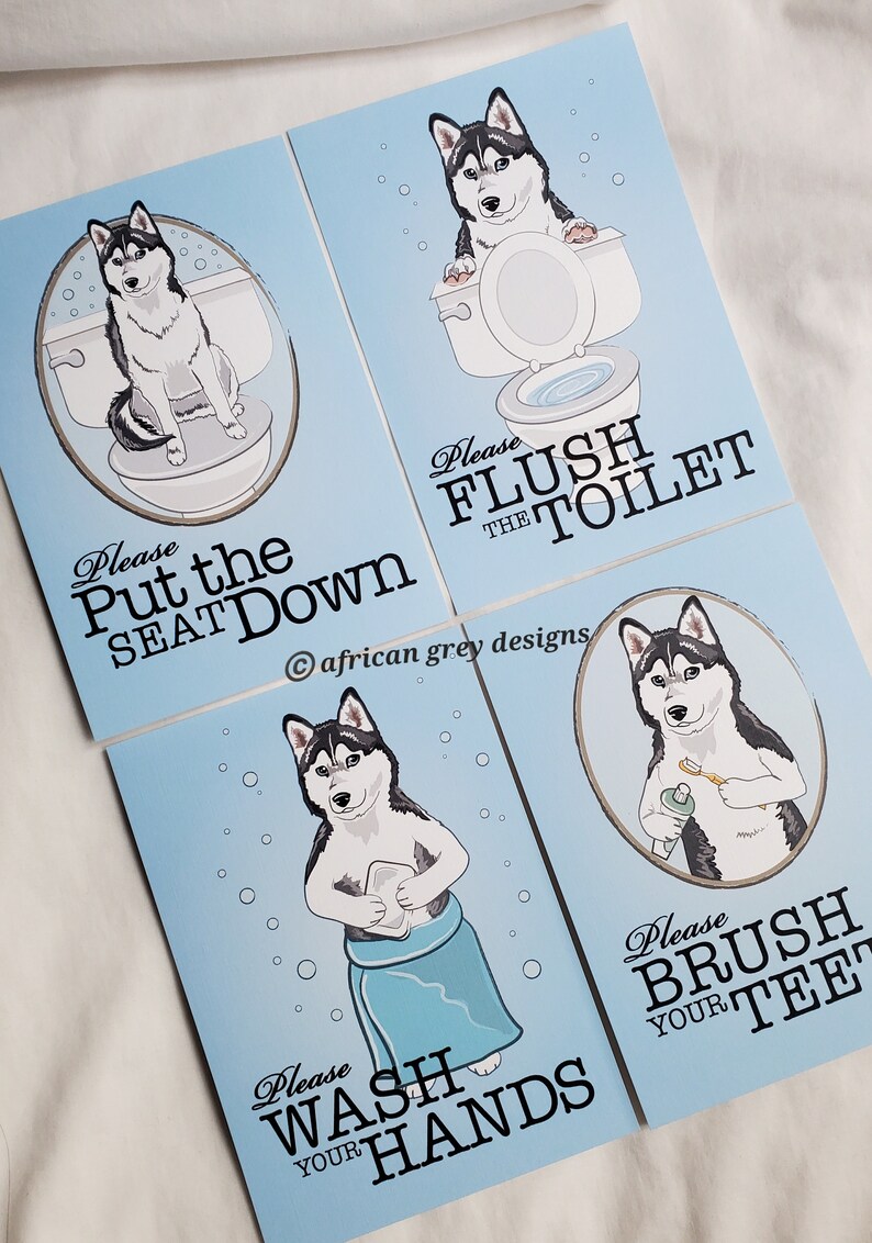 May include: Four blue signs with a cartoon husky dog on each. The signs have instructions for bathroom etiquette, such as "Please Put the Seat Down", "Please Flush the Toilet", "Please Wash Your Hands", and "Please Brush Your Teeth".
