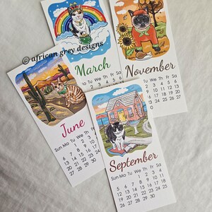 K&ouml;nnte beinhalten: Eine Sammlung von Kalendern mit Katzenmotiven f&uuml;r die Monate M&auml;rz, Juni, September und November. Jeder Kalender zeigt eine einzigartige Katzenillustration mit saisonalen Themen. Die Kalender sind auf wei&szlig;em Papier gedruckt.