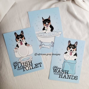 May include: Three blue cards with illustrations of a dog in different scenarios. The first card says "Please Flush the Toilet" and shows a dog sitting on a toilet. The second card shows a dog in a bathtub and says "african grey designs". The third card shows a dog with a towel and says "Please Wash Your Hands".