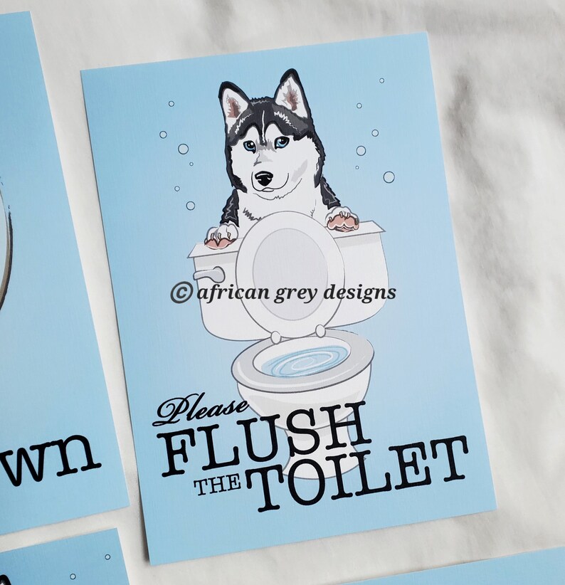 May include: A blue and white bathroom sign with a cartoon husky dog sitting on a toilet. The sign says "Please Flush The Toilet" with a copyright symbol and the text "african grey designs".
