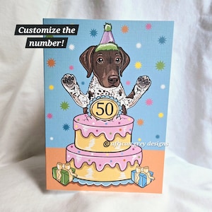 May include: A birthday card featuring a cartoon German Shorthaired Pointer dog wearing a party hat and sitting on top of a two-tiered cake. The cake is decorated with pink and yellow frosting and sprinkles. The number "50" is on the cake. The card has a blue background with white stars.