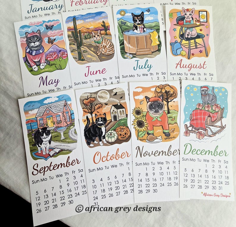K&ouml;nnte beinhalten: Eine Reihe von illustrierten Monatskalendern mit skurrilen Katzenillustrationen. Jeder Monat zeigt eine andere Katze in einer saisonalen Umgebung, mit dem Monatsnamen und den Daten darunter. Der Kalender wurde von African Grey Designs entworfen.
