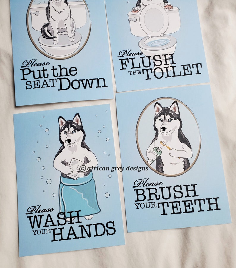 May include: Four blue signs with a cartoon husky dog on each. The signs have white text with instructions for bathroom etiquette. The signs read "Please Put the Seat Down", "Please Flush the Toilet", "Please Wash Your Hands", and "Please Brush Your Teeth".