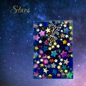 Könnte beinhalten: Ein rechteckiges Kunstwerk aus Harz mit einem Sternennacht-Thema. Das Stück ist mit bunten Sternen in verschiedenen Größen und Farben gefüllt, mit einem Sternschnuppen-Design. Das Wort "Stars" steht in goldener Schrift oben links.