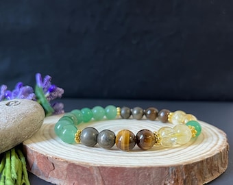 May include: A beaded bracelet featuring a sequence of round green aventurine, metallic pyrite, brown tiger eye, and translucent yellow citrine gemstones, accented with small gold-toned metal spacers arranged in a circular pattern.