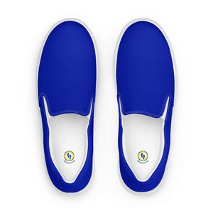 Può includere: Un paio di scarpe da ginnastica blu senza lacci con suole bianche e interno bianco. Le scarpe hanno una tomaia blu tinta unita e un design a punta tonda. L'interno presenta un logo.
