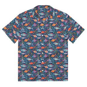 Könnte beinhalten: Ein kurzärmeliges Hemd mit einem lebendigen Fischmuster. Das Hemd hat einen marineblauen Hintergrund mit bunten Fischen in Orange, Blau und Lila, durchsetzt mit grünen Wasserpflanzen. Es hat einen klassischen Kragen und einen Knopfverschluss.