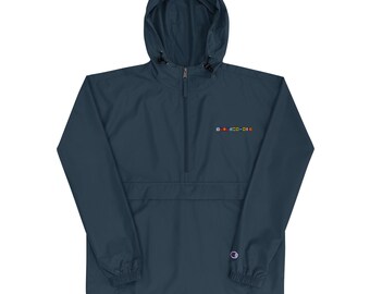 May include: A navy blue Champion anorak jacket with a hood and a half-zip closure. The jacket features a small, colorful embroidered design on the chest and the Champion logo on the left sleeve.