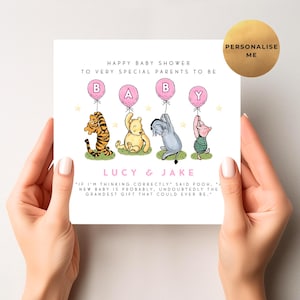 K&ouml;nnte beinhalten: Babyparty-Karte mit Winnie-the-Pooh-Figuren, die Buchstabenballons halten. Die Karte tr&auml;gt die Aufschrift "Happy Baby Shower" und "Lucy & Jake". Ein goldener Kreis mit "Personalise Me" befindet sich oben rechts.