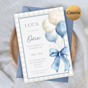 Puede incluir: Una invitación de cumpleaños azul y blanca con el texto "LUCA IS TURNING ONE". La invitación presenta globos y un lazo de acuarela. La invitación incluye la fecha, la hora y el lugar de la fiesta.