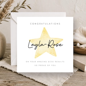 May include: A square white greeting card featuring a yellow watercolour star in the centre. The text reads CONGRATULATIONS, Layla-Rose, ON YOUR AMAZING GCSE RESULTS, and SO PROUD OF YOU in black lettering. The card is paired with a white envelope.