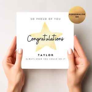 May include: A white congratulations card held by hands, with a yellow watercolour star and the word "Congratulations" in script. The card also includes the name "Taylor" and the phrase "Always knew you could do it."