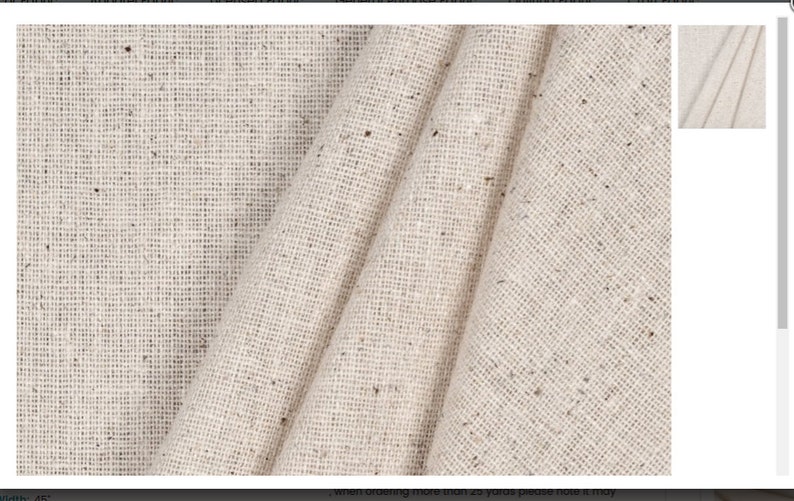 Puede incluir: Primer plano de una tela beige con un sutil patr&oacute;n moteado. La tela est&aacute; doblada y tiene un aspecto suave y texturizado.