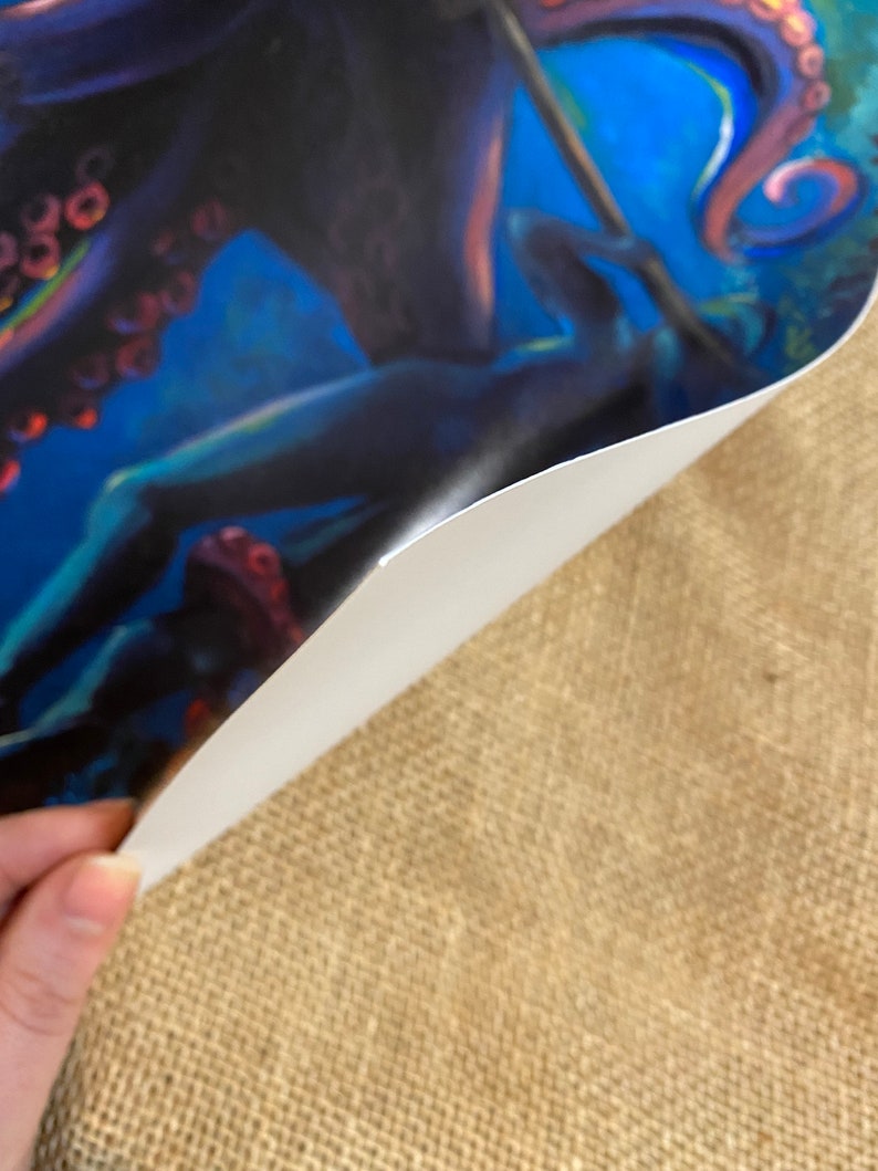 May include: A close-up of a colorful painting of an octopus with tentacles. The octopus is painted in shades of blue, purple, and pink. The background is a dark blue with hints of green.