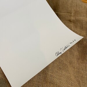 May include: A white sheet of paper with a black signature that reads "Abby Voorhees" in cursive.