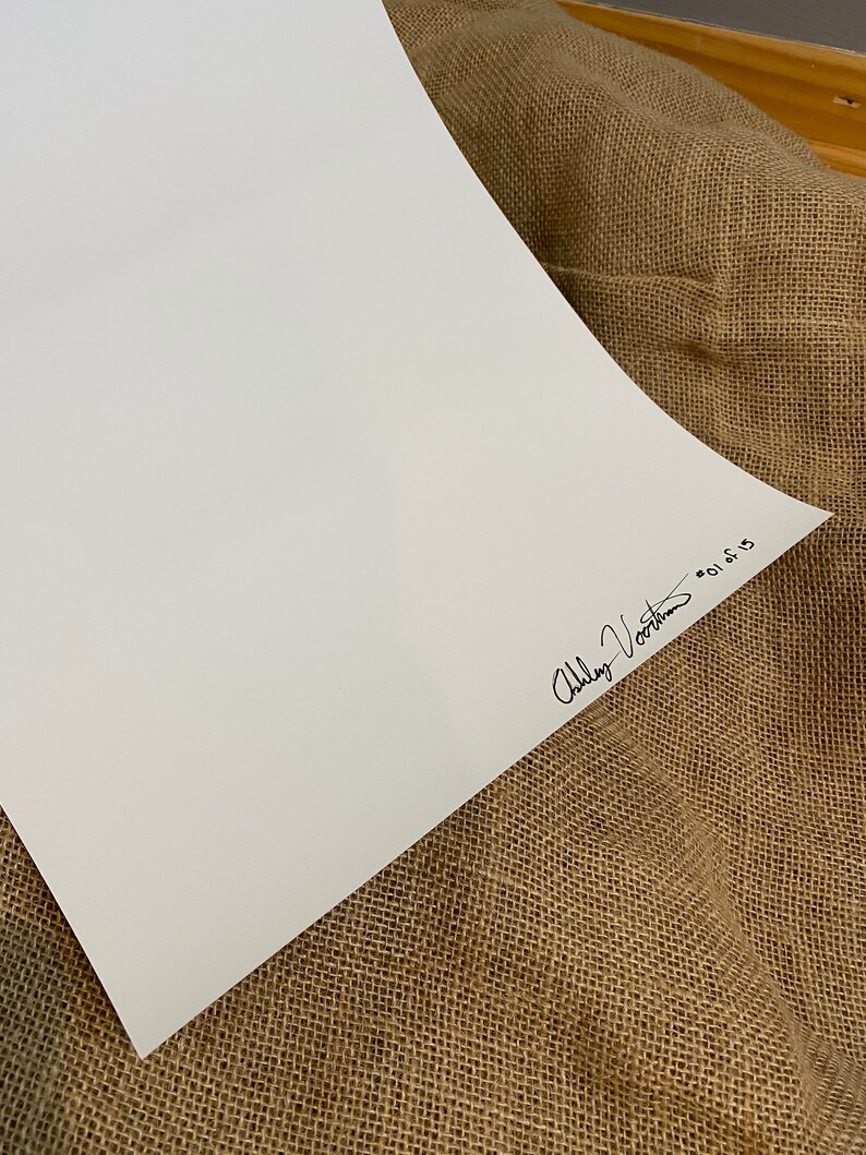 May include: A white sheet of paper with a black signature that reads "Abby Voorhees" in cursive.