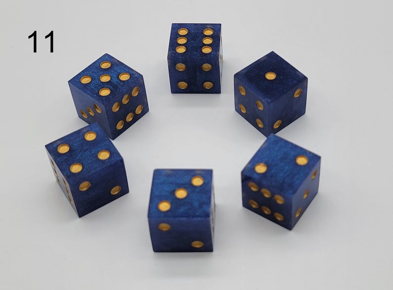 May include: Six blue dice with a marbled texture and gold-colored pips arranged in a circular pattern. Each die is a cube with rounded edges. The number 11 is printed in black in the upper left corner of the image, indicating the set number.
