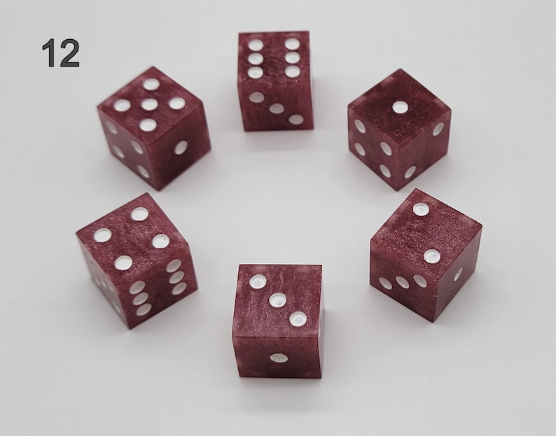 May include: Six six-sided dice arranged in a circle, each featuring a deep maroon, marbled resin finish with white pips. The number 12 is printed in black in the upper left corner. Each die displays different face values including one, two, three, four, five, and six.