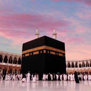 May include: The Kaaba, a black cube-shaped structure, stands in the center of the Grand Mosque in Mecca. The image shows a large crowd of people in white garments. The sky is a mix of pink, blue, and orange hues.