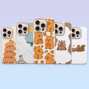Könnte beinhalten: Eine Sammlung von fünf Handyhüllen mit Cartoon-Capybaras und Bären in verschiedenen Designs. Die Hüllen zeigen verschiedene Illustrationen, darunter gestapelte Capybaras, Bären mit Orangen und Bären in einer Landschaft. Die Hüllen haben einen transparenten Rand.