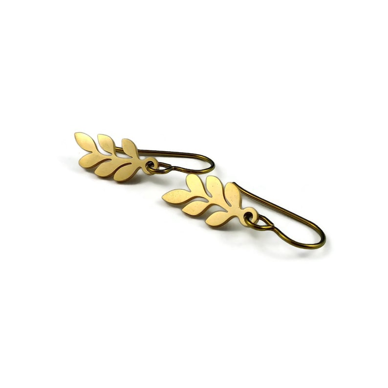 May include: A pair of gold leaf-shaped earrings with a simple wire hook closure.