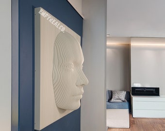 May include: A white 3D wall sculpture of a face with a layered design. The sculpture is mounted on a blue wall in a modern home interior.