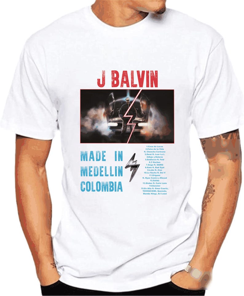 Pode incluir: Camiseta branca com uma estampa gr&aacute;fica de J Balvin, um carro e um raio. O texto "Made in Medellin, Colombia" est&aacute; impresso abaixo do gr&aacute;fico. A lista de faixas do &aacute;lbum "Jose" est&aacute; impressa no lado direito da camiseta.