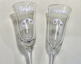 Handcuff- themed wedding champagne glasses, bride and groom