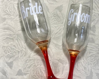 Bride and groom wedding champagne toasting flutes.  Red wedding toasting glasses. Valentine's wedding