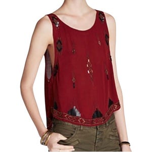 May include: A sleeveless burgundy top with decorative beading. The top has a scoop neck and a beaded border along the hem. The embellishments include black, gold, and silver beads. The top is worn with olive green trousers.