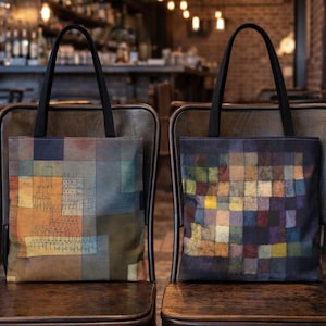 Puede incluir: Dos bolsos tote con asas negras y diseños de arte abstracto. Una bolsa presenta un diseño con cuadrados naranjas, azules y marrones. La otra bolsa tiene un diseño con una variedad de cuadrados coloridos.