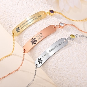 Könnte beinhalten: Drei medizinische Notfallarmbänder in Gold, Roségold und Silber. Jedes Armband hat eine rechteckige Platte mit eingraviertem Text und einem medizinischen Symbol. Das goldene Armband lautet "Adrenal Insufficiency Emmaleigh, 123 456 7890".