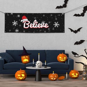May include: A festive Halloween and Christmas-themed living room scene. A black banner with the word "Believe" in white and red, adorned with snowflakes and a Santa hat. Carved pumpkins, candles, and bat decorations complete the holiday decor.